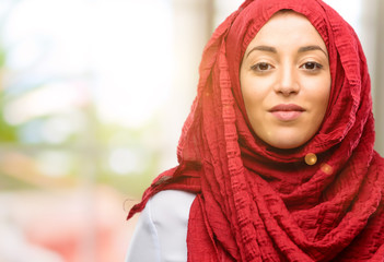 Young arab woman wearing hijab confident and happy with a big natural smile looking at camera