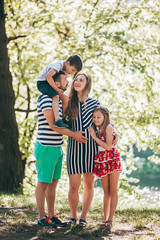 Fototapeta premium Happy family in the park.Pregnant mother with her family on vacation
