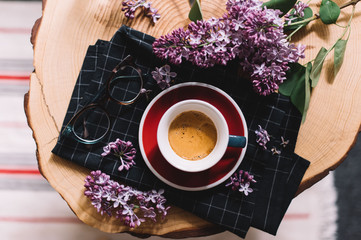 Delicious fresh morning coffee in a ceramic cup with a beautiful crema, reading glasses and a...