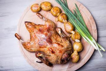 Duck baked whole, with potatoes and garlic. Selective focus, close-up.