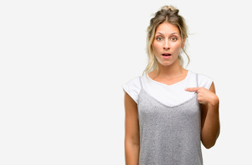 Young beautiful woman happy and surprised cheering expressing wow gesture, pointing with finger