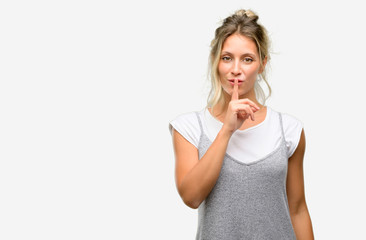 Young beautiful woman with index finger on lips, ask to be quiet. Silence and secret concept