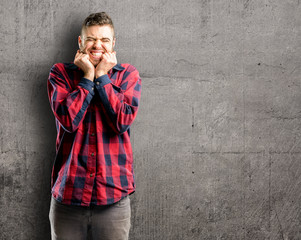 Young handsome man confident and happy with a big natural smile laughing