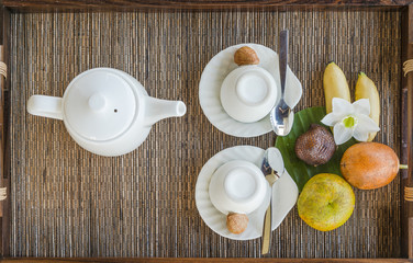 one porcelain kettle two porcelain teacup on wooden tray table top view