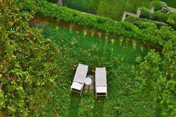 Two deck chairs in a beautiful garden on a grassy lawn; aerial view
