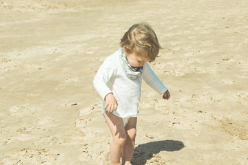 Little girl playing with the sand on the beach .Children playing on the beach