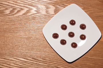 A lot of variety chocolates in box on wooden background