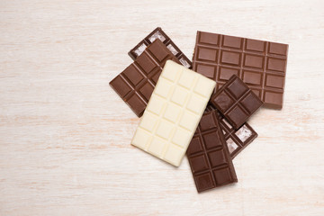 A lot of variety chocolates bar in box on white wooden background