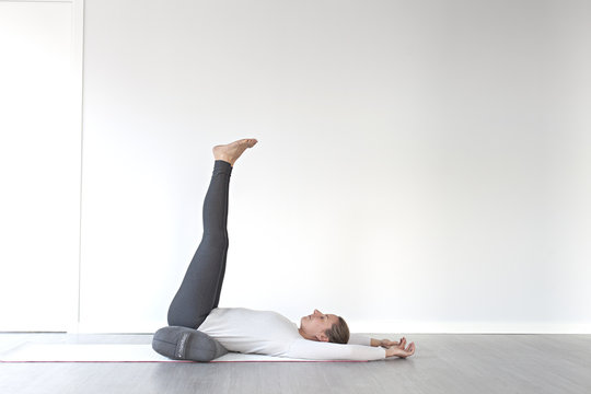 Girl using bolster for a back release yin yoga pose