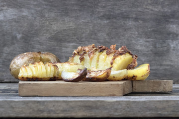 Baked potatoes of different kinds located on a wooden background in rustic style close-up