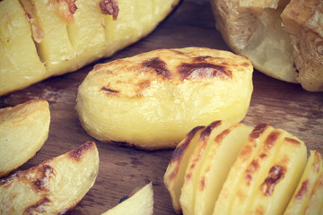 Baked potatoes of different kinds located on a wooden background in rustic style close-up