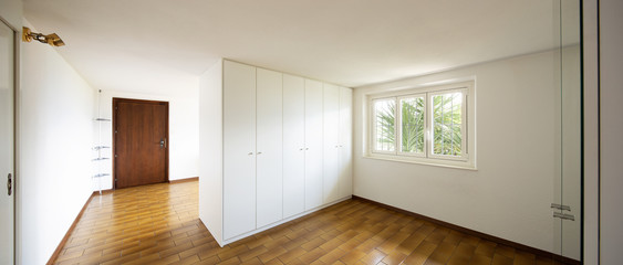 Spacious rooms with large white wardrobes.