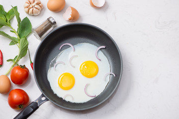 Eating in the process, fried eggs in a frying pan for breakfast on a white background. Daylight.