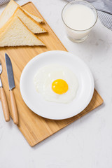 Fried eggs with toasts and milk on the table