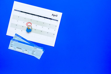 Plan a trip. Buy airplane tickets. Tickets near calendar with date circled on blue background top...