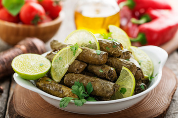 Dolma, stuffed grape leaves with rice and meat on wooden  background .