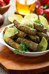 Dolma, stuffed grape leaves with rice and meat on wooden  background .