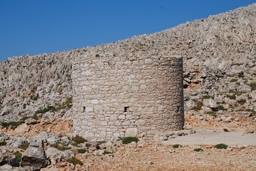Fototapeta premium An old stone windmill on the high plateau of the Greek island of Halki.