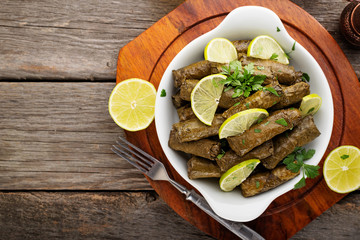 Dolma, stuffed grape leaves with rice and meat on wooden  background . top  view.