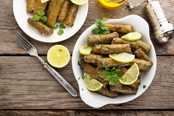 Dolma, stuffed grape leaves with rice and meat on wooden  background . top  view.