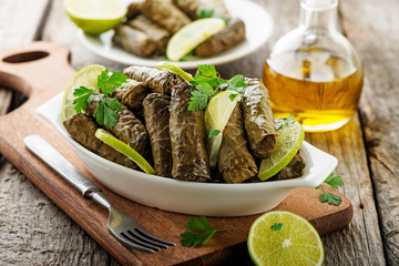 Dolma, stuffed grape leaves with rice and meat on wooden  background .
