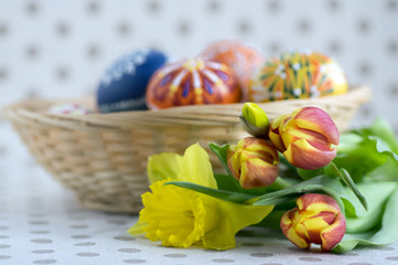 Homemade handmade painted Easter eggs on wicker basket, traditional handcraft eggs