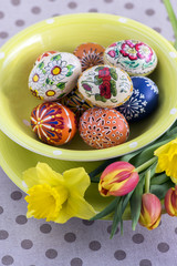 Group of wax painted Easter eggs in green spotted bowl