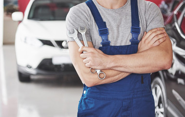 Hand of car mechanic with wrench. Auto repair garage