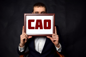 In the hands of a businessman a frame with the inscription:CAO