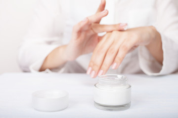 Closeup shot of woman hands applying moisturizing hand cream