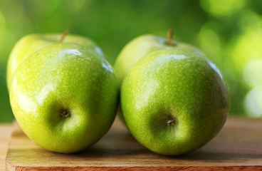 Green apple on wooden table over green background