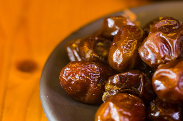 dried dates in a ceramic plate on a wooden table