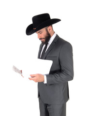 Man in suit and hat reading papers