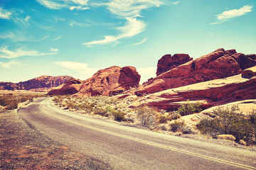 Vintage toned deserted road, travel concept, Valley of Fire, Nevada, USA.