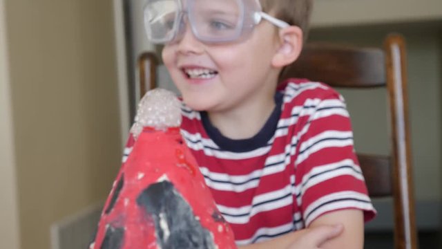 A cute little boy and mother prepare to do a volcano science experiment