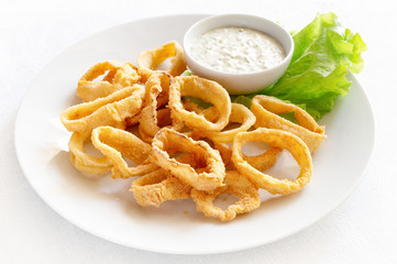 calamari with sauce decorated with lettuce leaf