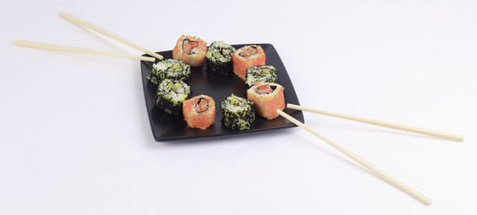 Obraz na płótnie Canvas Sushi Set - different types of Maki sushi on a black plate.