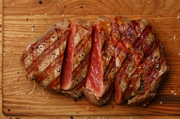 Close up grilled beef steak on wooden board