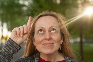 Woman having an idea just when a ray of sunlight illuminates her