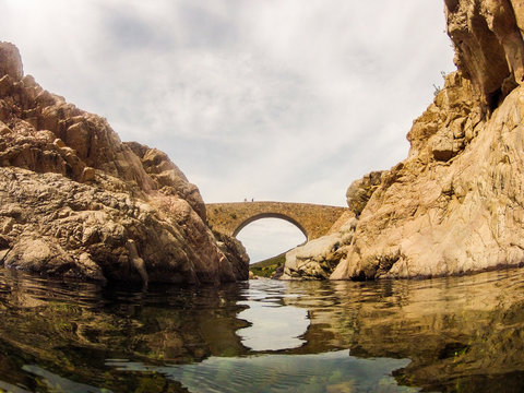 Ponte Vecchiu Bridge Over The Boulder Strewn Fango River Near Galeria In Corsica