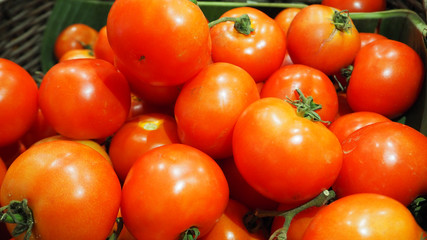 Fresh red tomatoes in basket at market.