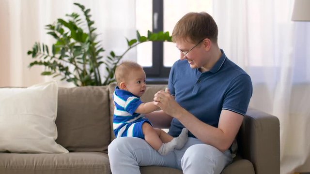 family, fatherhood and childhood concept - happy baby boy with father at home