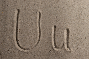 Letters of the English alphabet drawn on sand 