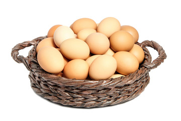 Beige chicken eggs in a brown wicker basket