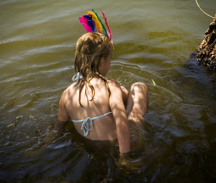Little girl playing make believe in a pond