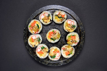 Korean dried Seaweed Rolls, gimbap. Made with carrot, eggs, kim, rice, salt, sesame oil, vinegar, sesame seeds, yellow radish, carrots, ham, spinach, fish cakes, burdock, eggs, rice, crab meat.