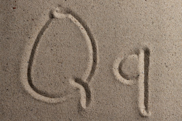 Fototapeta na wymiar Letters of the English alphabet drawn on sand 