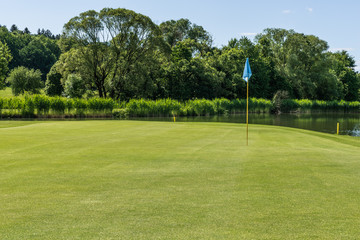 Obraz premium Golfplatz mit blauer Flagge