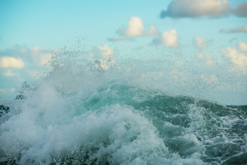 Wave, splashes in the ocean and the sky. Close view.
