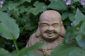 Buddha Statue im Blumenbeet